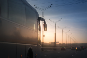 Bus driving on a road in the sunset