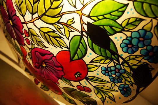 Colorful round hand-painted glass lamp with stained glass paints, with a floral pattern with leaves and flowers
