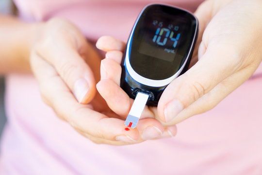 Someone measuring blood sugar level with blood glucose metr, world diabetes day concept