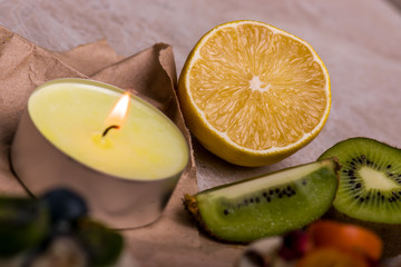 Fototapeta na wymiar Kiwi, lemon, candle on the table. Fruit close-up.