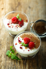 Homemade tiramisu dessert decorated with fresh raspberry and rose petals