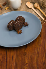 Brown biscuit on a blue plate. Cookies with cinnamon on a wooden table.