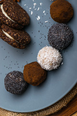 Sweets with poppy, coconut, chocolate, cinnamon on a blue plate close-up