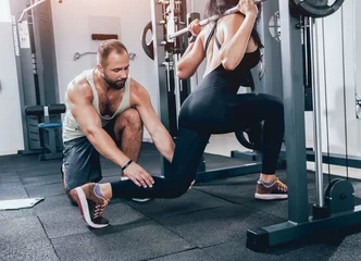  Fitness woman exercising with fitness trainer in gym. Personal fitness instructor. © romaset
