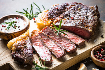 Grilled beef steak ribeye on wooden cutting board. 