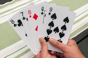 Female hand holding five different playing cards closeup