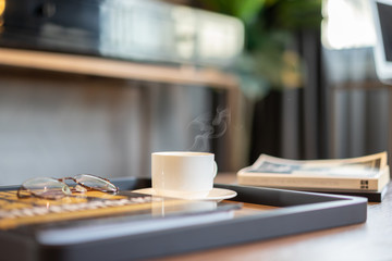 Cup of coffee on the desk in the morning.