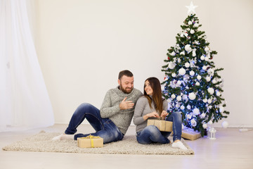 husband and wife Christmas Christmas tree with gifts