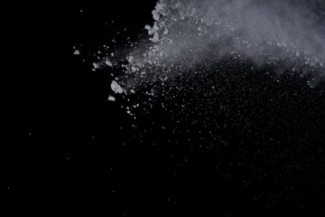 White powder explosion on black background. Dust splatted isolated. Paint Holi.