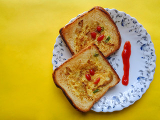 Bread egg toast with tomato ketchup on yellow background