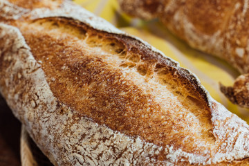 Close up Freshly and warm baked baguette in the basket on wooden table. Made by artisan.