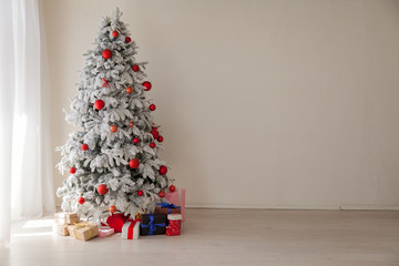 Christmas Decor Christmas tree with presents in a white room in winter