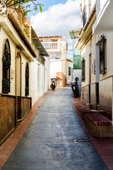 beautiful and picturesque narrow street with white facades of buildings, Spanish architecture