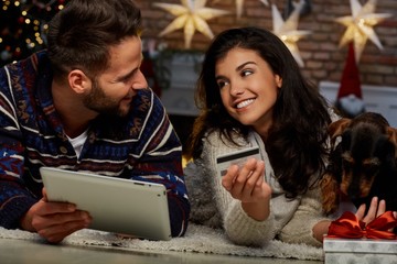 Christmas couple shopping on tablet at home
