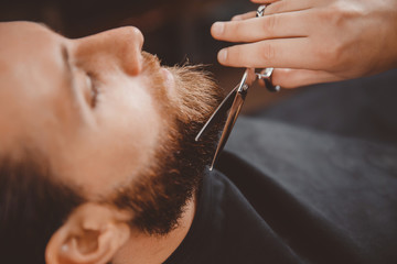 Hipster client man visiting in barber shop shaving beard