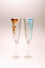 The effect of water smoke using an red and blue food coloring in two glasses for champagne on a white background.
