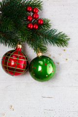 Evergreen fresh twigs with red and green decorations, flat lay border with copy space