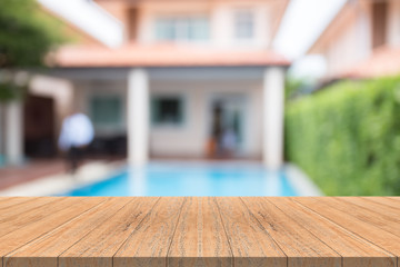 Empty wood table top on blurred background at swimming pool in garden