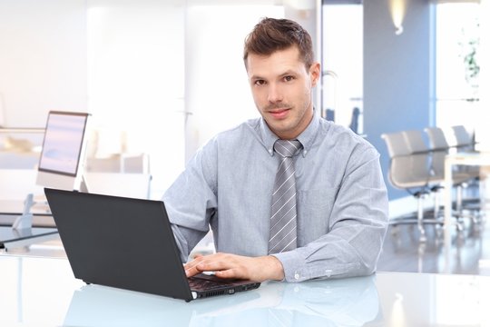 Young businessman using laptop at office