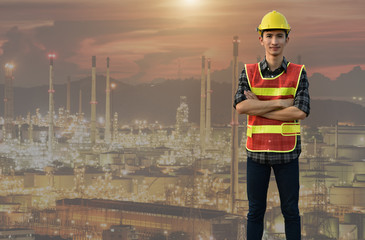 Young Asian in a safe suit Basic safety equipment in the factory on the background of the oil and gas industry.Concept of safety control in work