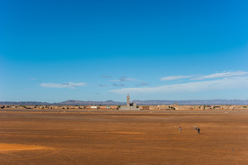 Fototapeta na wymiar View from the dunes to the city Merzouga in Morocco, Africa