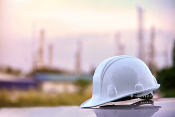 Fototapeta na wymiar White safety helmet and industrial background, Safety concept, Refinery background.