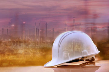 Fototapeta na wymiar White helmet and industrial background, Safety concept, Refinery background.