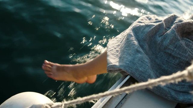 Woman in a linen dress chattering on a yacht against the sea