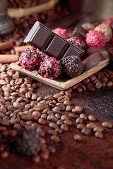Various chocolates in wooden dish on a brown table.
