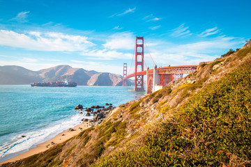 Fototapeta na wymiar Golden Gate Bridge with cargo ship at sunset, San Francisco, California, USA
