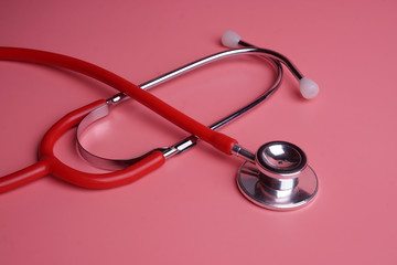 Stethoscope on pink background.
