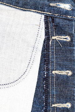 Closeup of blue jeans fabric with pocket. Wrong side