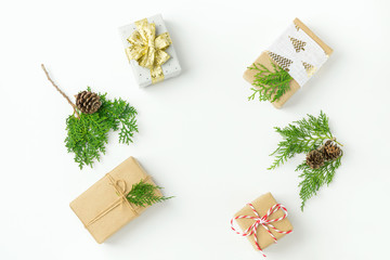 Fototapeta na wymiar Christmas gift boxes wrapped in brown craft paper golden ribbon bow pine cones juniper arranged in circle on white background. New Year presents holiday preparations. Minimalist poster banner mockup