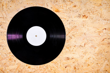 Black color vinyl record on plywood background