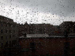 An amazing photography of some waterdrops over the window after summer rain in the city