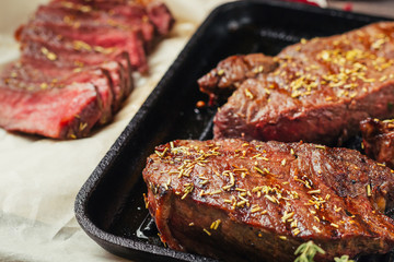 Grilled beef steak on frying pan, top view. Fried chunks of meat close up