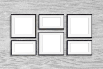 Black photo frames mock up on wooden panels wall