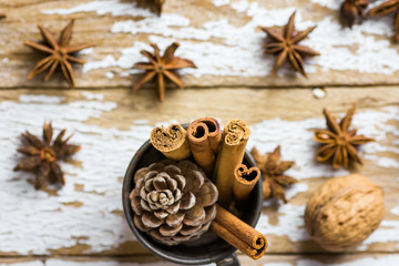 Vintage Christmas Greeting Cad with Baking Ingredients Decoration Cinnamon Sticks Anise Stars Pine Cones in Jug on Snowy Wood Background. Festive New Year Poster. Cozy Atmosphere