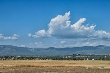 Campo con cielo/ vista de la dehesa boyal con la sierra de Guadarrama al fondo en Collado Villalba, provincia de Madrid. España