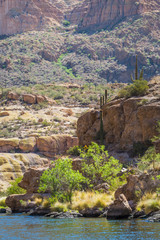 Arizona desert is diverse red slick rock cliffs surround Canyon Lake in the wilderness east of Phoenix with desert plants adding to the beauty of these landscape photographs