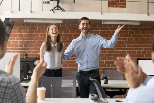 Excited company boss or team leader introducing new employee to colleagues in office welcoming hired newcomer member congratulating with promotion applauding celebrating reward, supporting coworker - Powered by Adobe