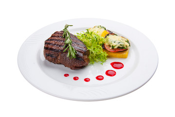 Beef steak with grilled vegetables and an omelette. On a white plate