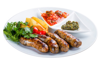 Homemade sausages with potatoes and sauce. On a white plate