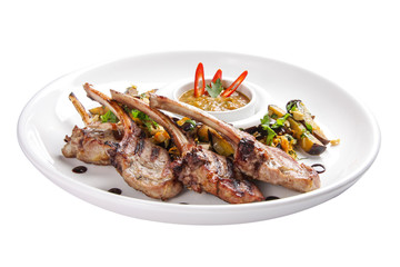 Baked rack of lamb with onions on a white plate