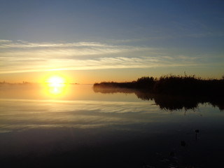 Fototapeta na wymiar Утро на реке осень туман солнце утка донки рыба