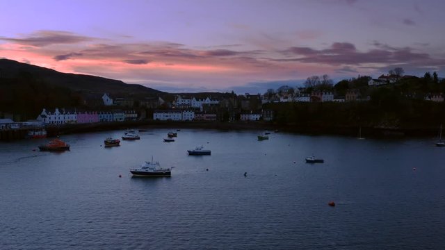 Portree low aerial shot at dusk with boats in the harbour, Isle of Skye.