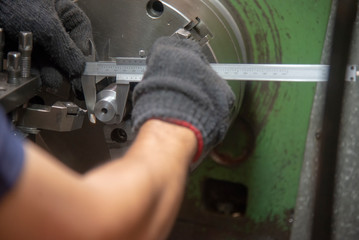 The operator use the vernier caliper measure the part on lathe machine.The vernier caliper measure...