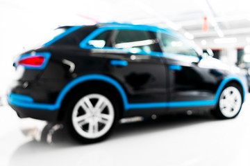 Plakat Blurred abstract image of man worker with car in body shop. Blur car auto service. Car bokeh. Blurred background with car in garage. Vehicle maintenance in auto repair service. Blurry service station