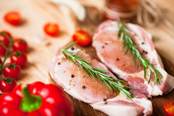 Fresh raw pork on the cutting board with ingredients for cooking. Food, flat lay, recipes and nutrition concept. Top view. Close up.