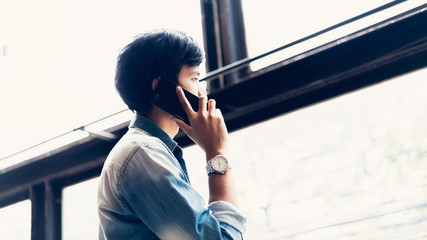 Man using smartphone on staircase in public areas, During leisure time. The concept of using the phone is essential in everyday life.